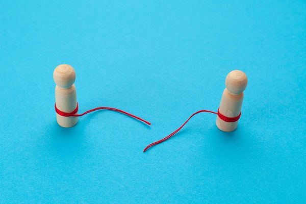 Conflict in a pair. Two figures of people with a torn thread