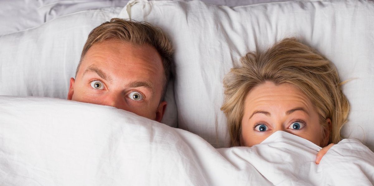 Couple hiding under sheets