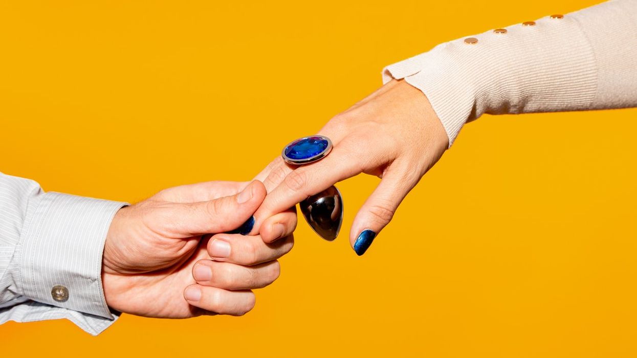 couple holding hand with blue butt plug