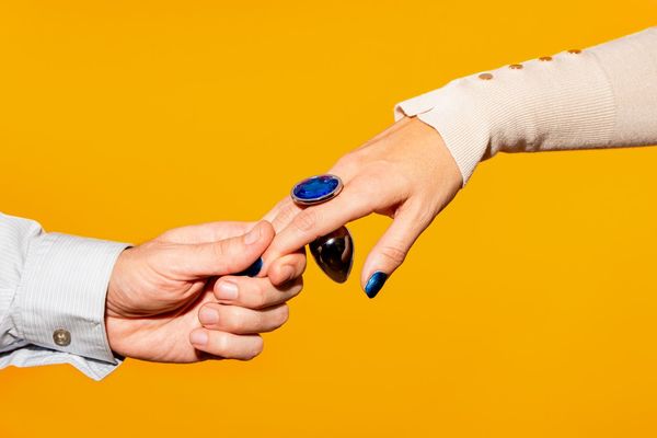 couple holding hand with blue butt plug