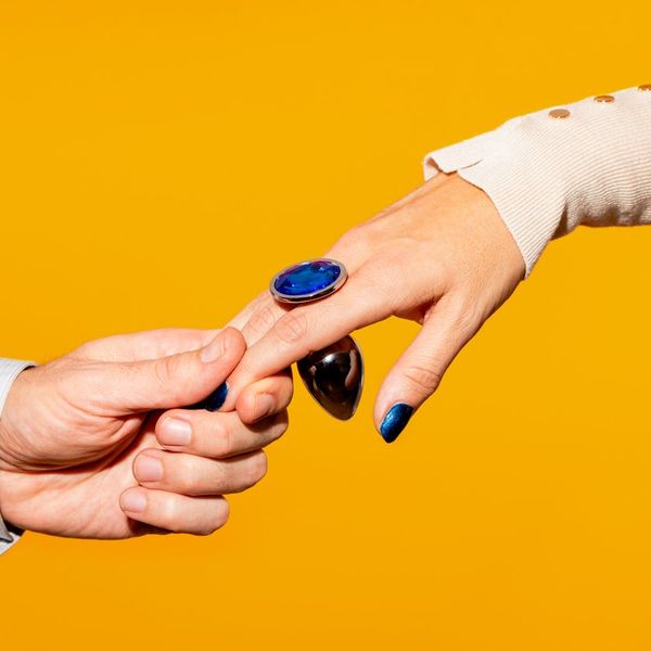 couple holding hand with blue butt plug