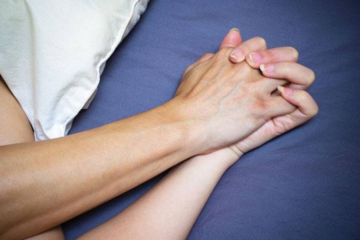 couple holding hands in bed
