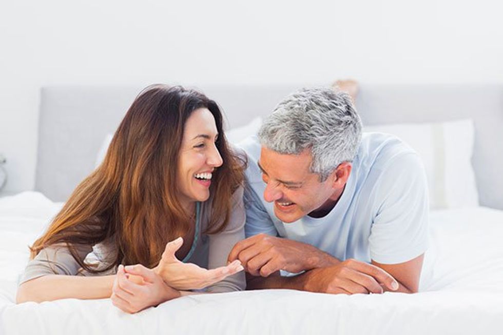 couple laughing and laying in bed