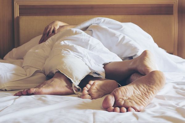 Couple Sleeping On Bed At Home