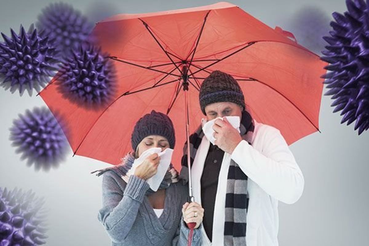 couple under an umbrella blowing their noses