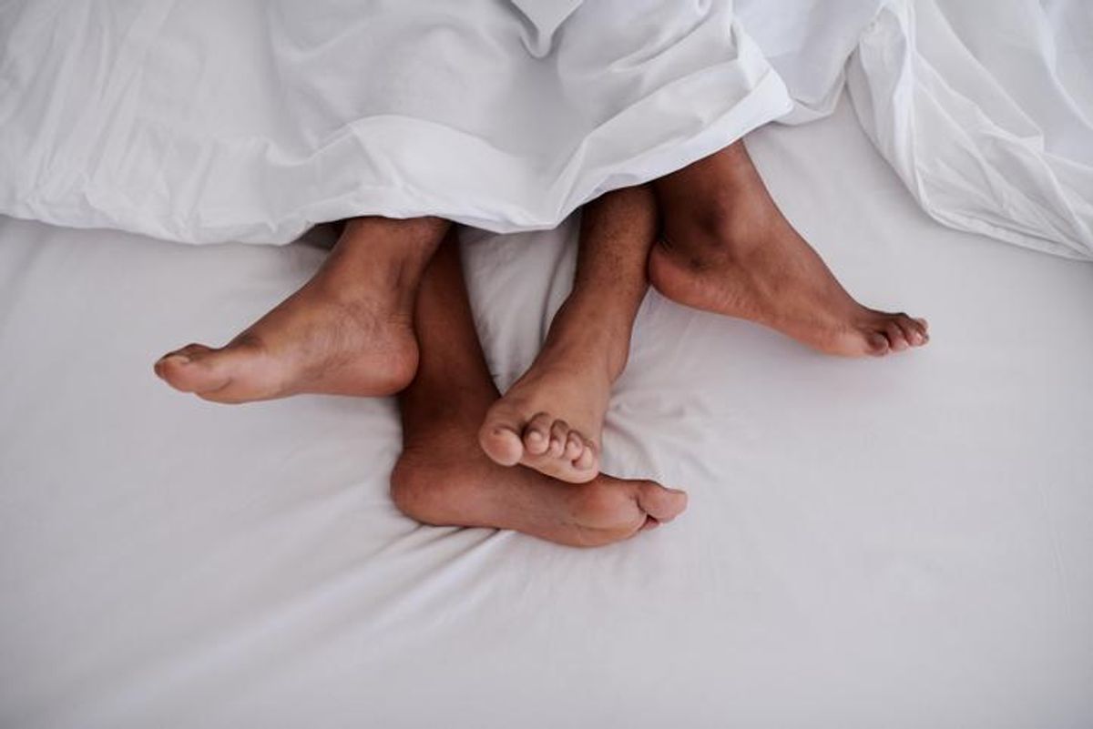 Cropped shot of an unrecognizable couple lying in bed together