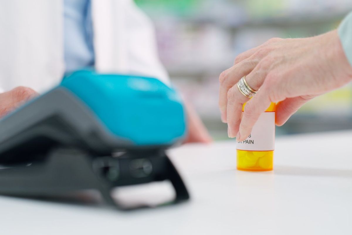customer purchasing a bottle of pills in a pharmacy