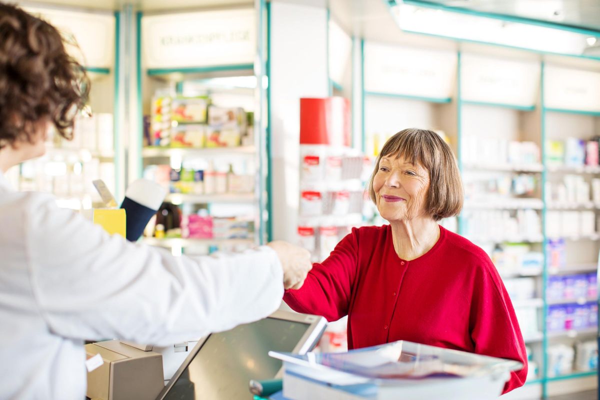 Customer receiving medication from pharmacist