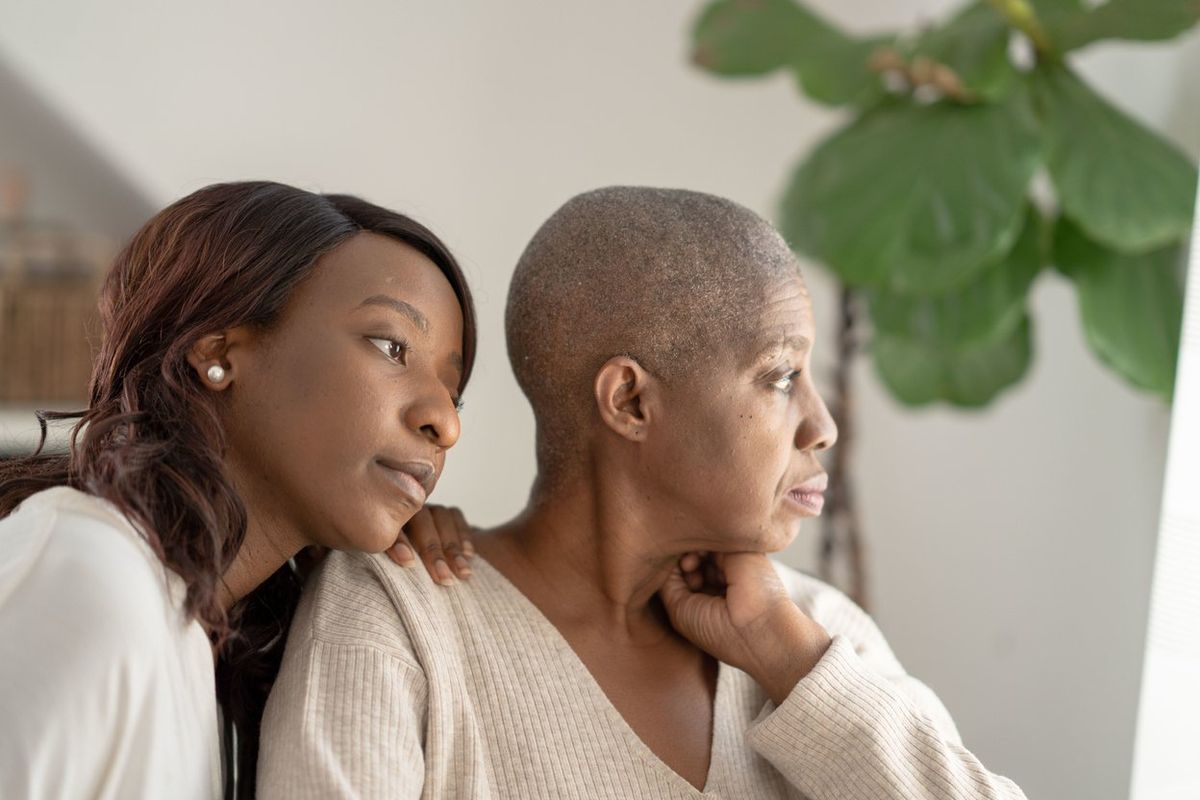 daughter sitting with mom who is battling cancer 