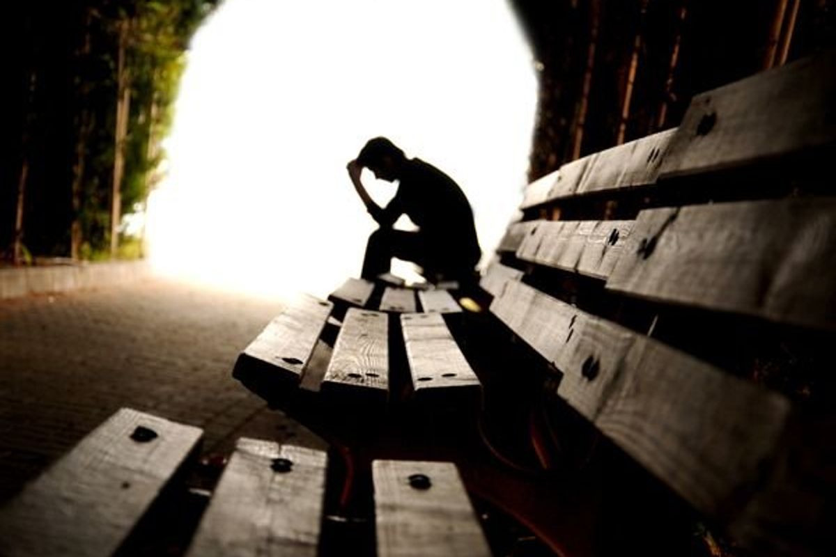 depressed person sitting on a bench