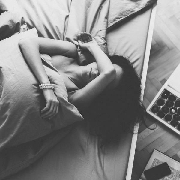 Depressed woman in bed with hand on forehead