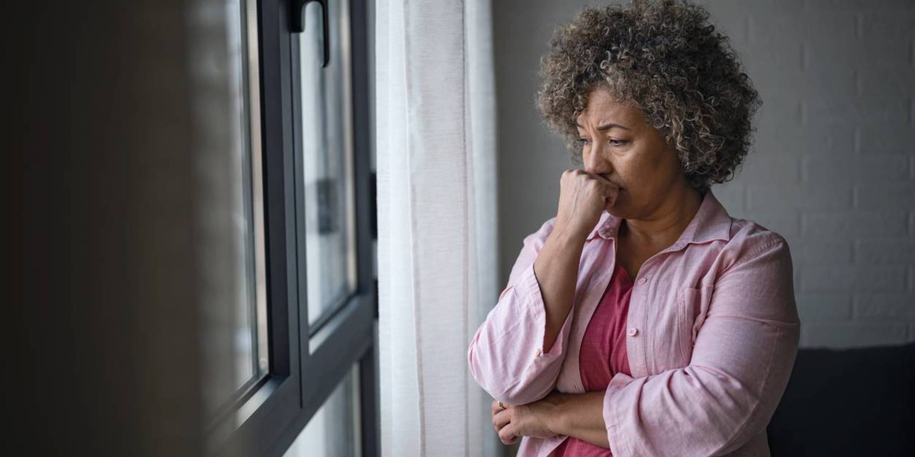 depressed woman looking out a window