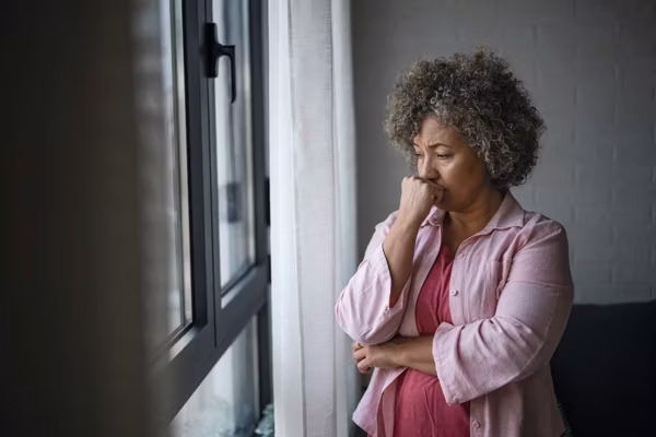 depressed woman looking out a window