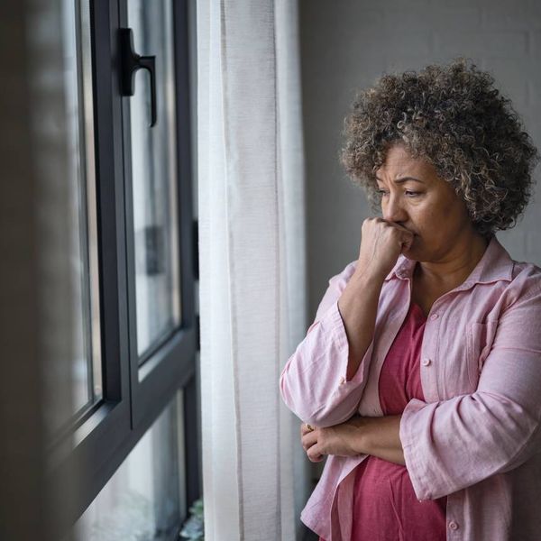 depressed woman looking out a window