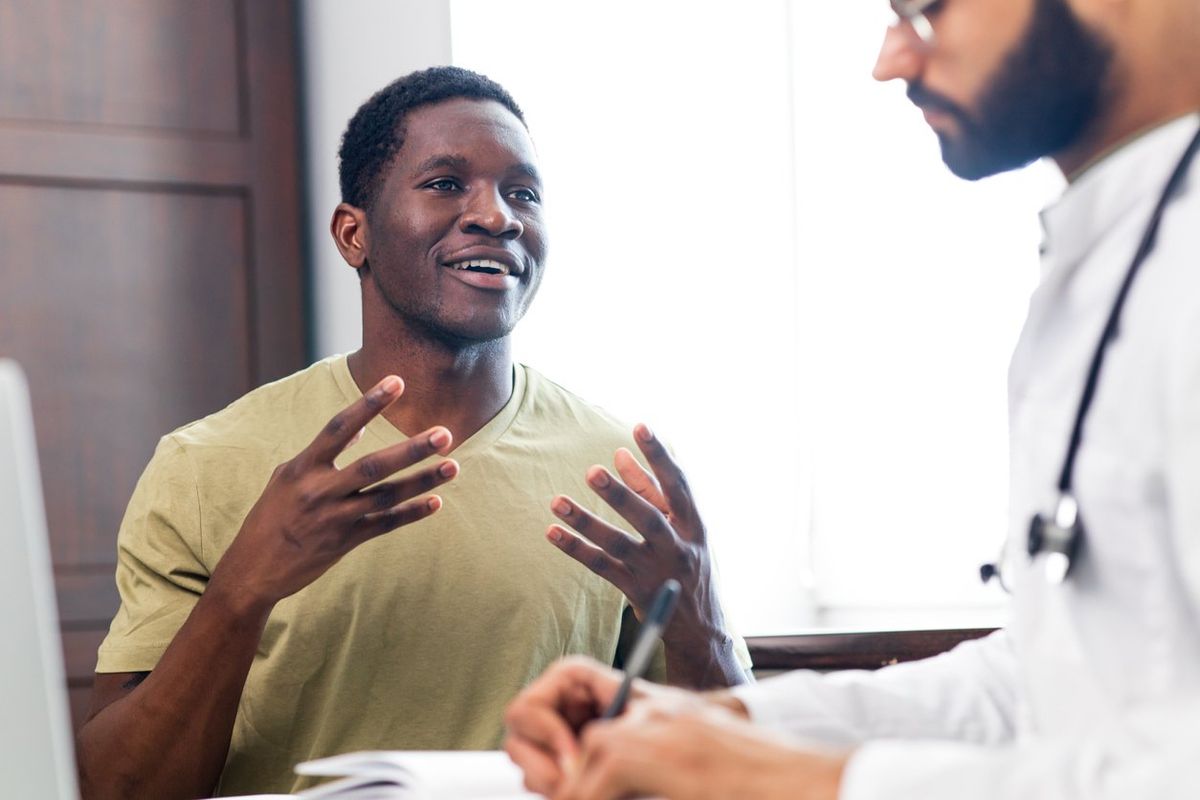 Doctor and male patient talking at office consultation