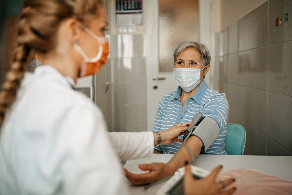 doctor checking patient's blood pressure