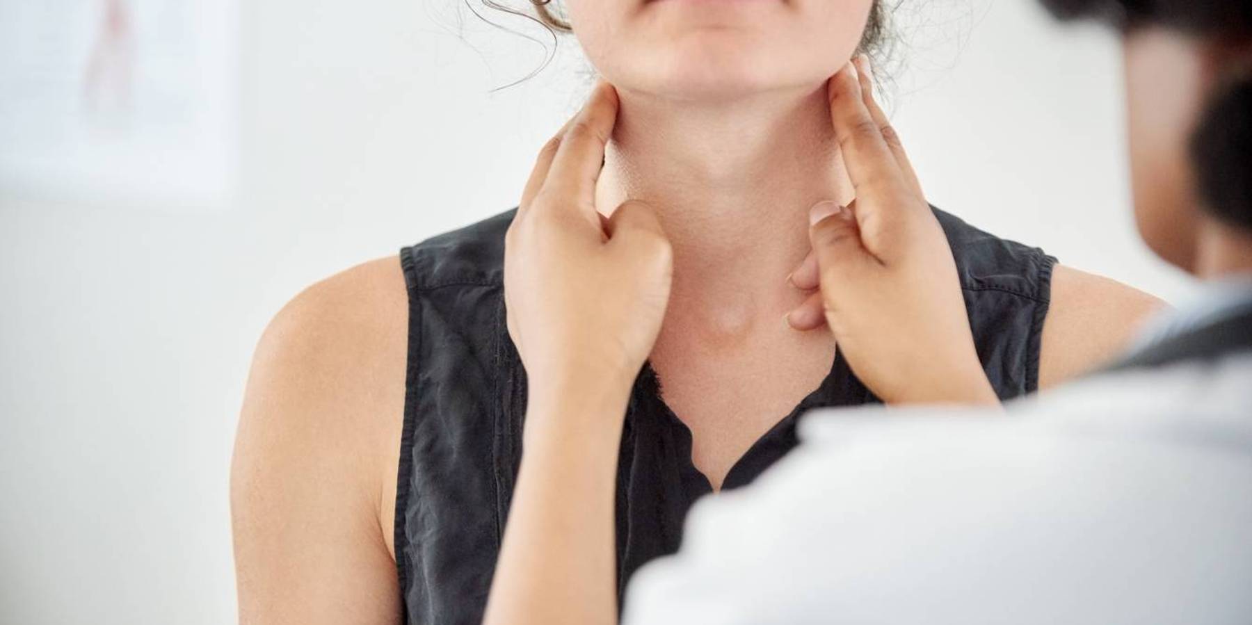 Doctor checking thyroid of a young patient