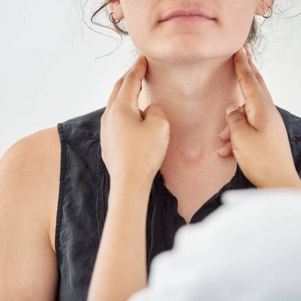 Doctor checking thyroid of a young patient