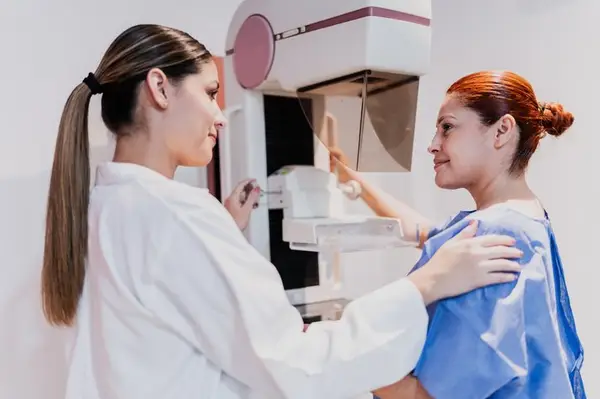 Doctor doing mammogram exam on patient at hospital. Mammograms are one way to detect DCIS.