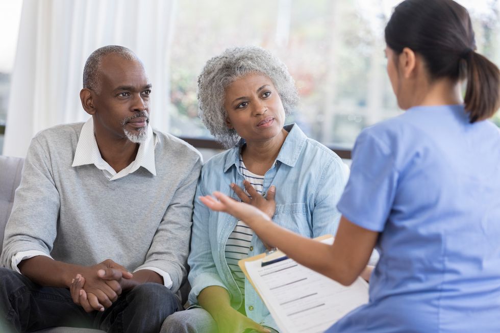 doctor gestures a she discusses a senior couple's health concerns.