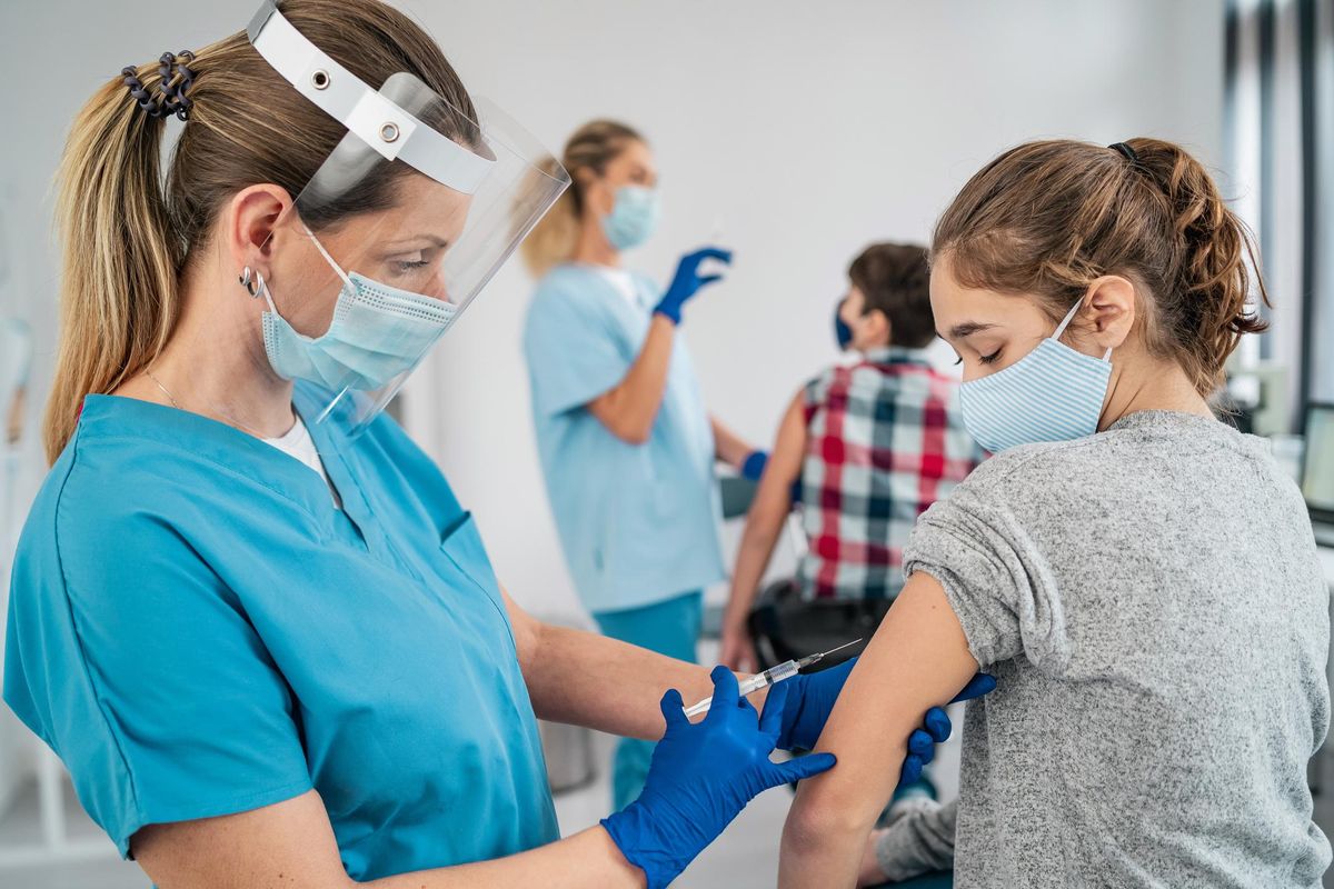 Doctor giving a girl a covid vaccine