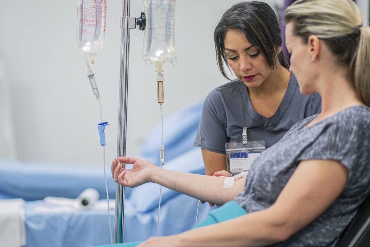 Doctor giving intravenous drip of Immunotherapy treatment for Melanoma to a female patient