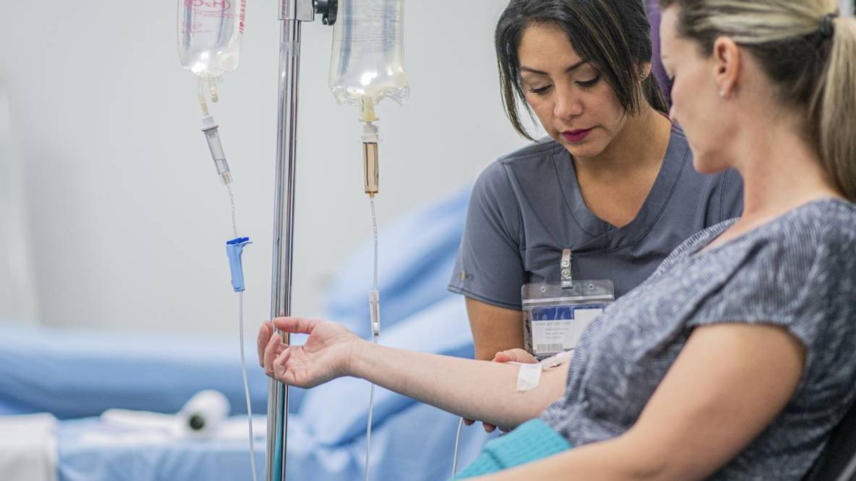 Doctor giving intravenous drip of Immunotherapy treatment for Melanoma to a female patient