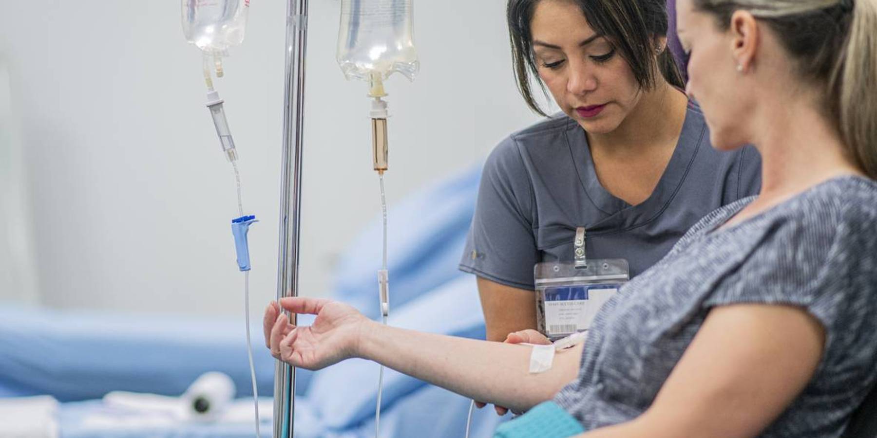 Doctor giving intravenous drip of Immunotherapy treatment for Melanoma to a female patient