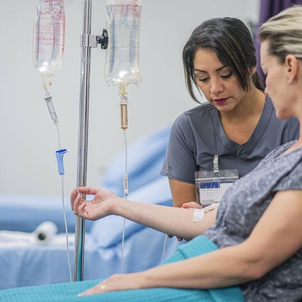 Doctor giving intravenous drip of Immunotherapy treatment for Melanoma to a female patient