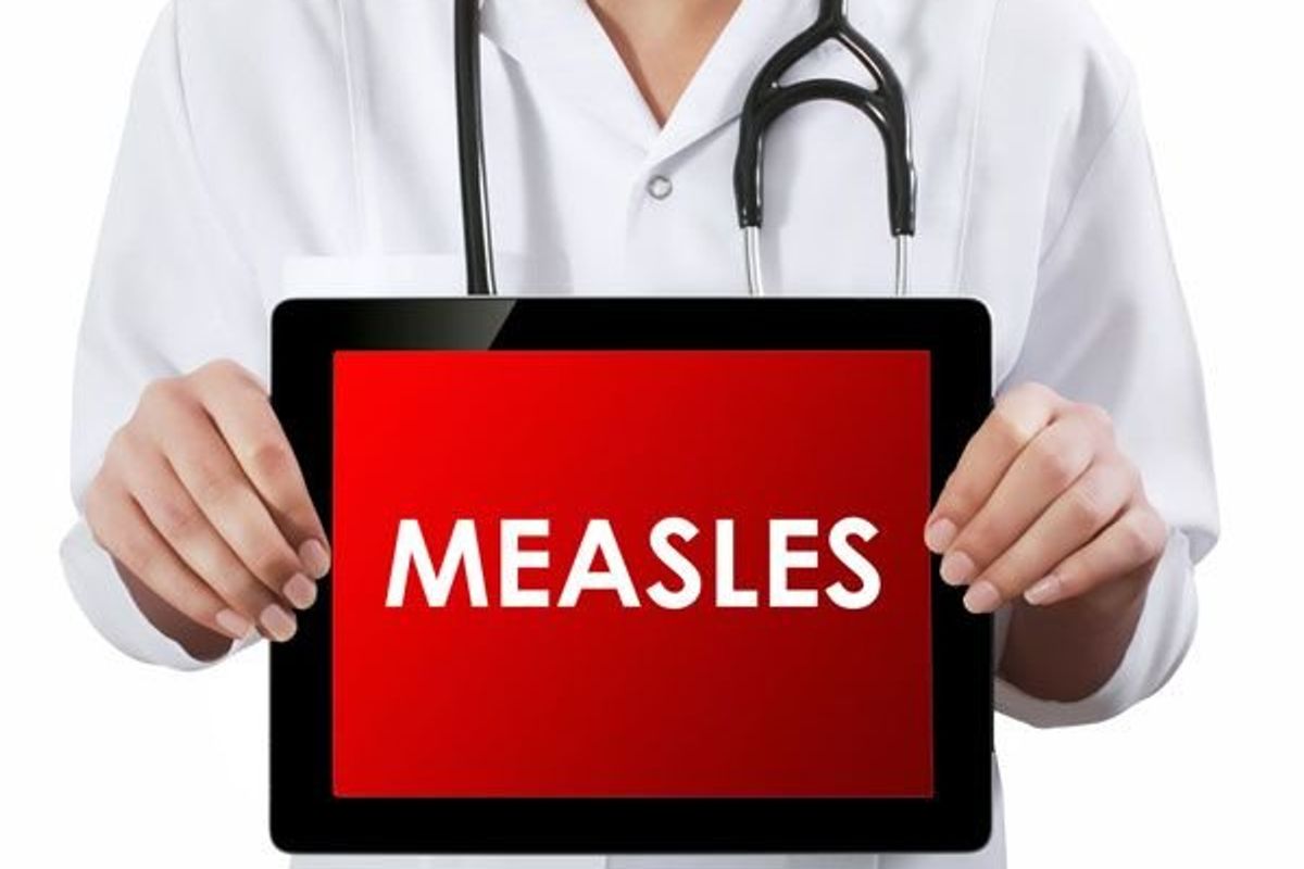 doctor hold a sign that says measles