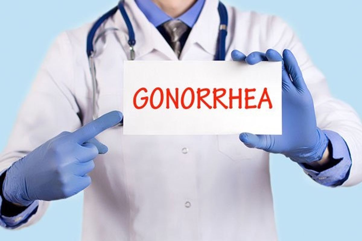 doctor holding a sign that says gonorrhea