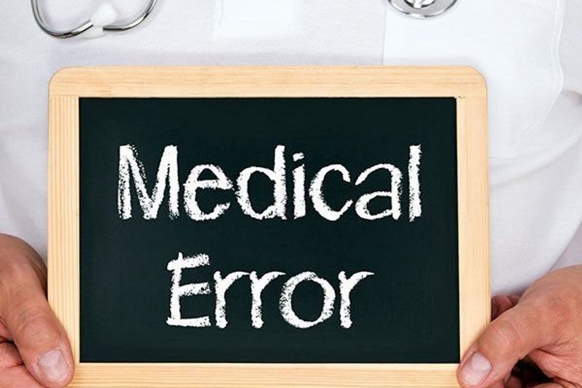doctor holding a sign that says medical error
