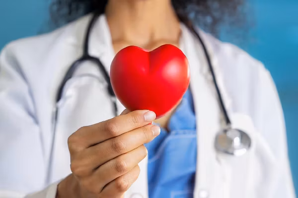 doctor holding red heart shape in hand
