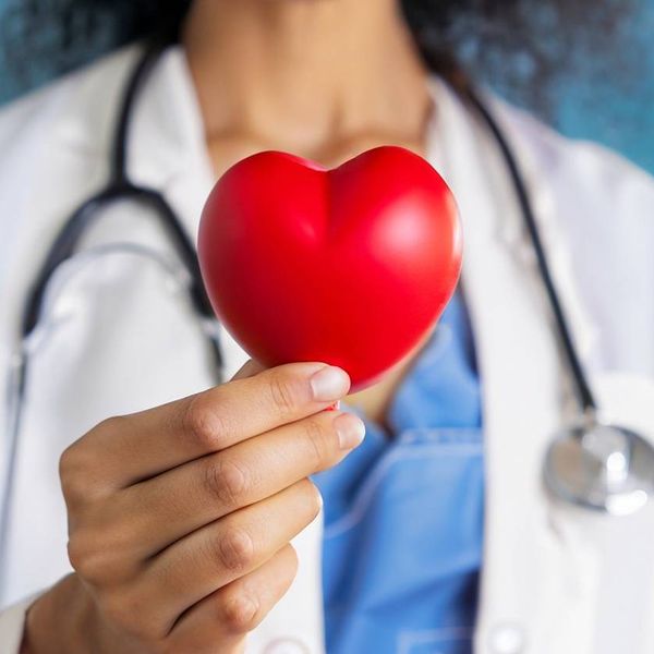 doctor holding red heart shape in hand