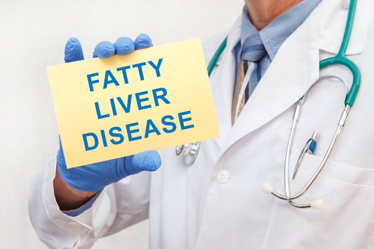 Doctor holding sign with text FATTY LIVER DISEASE