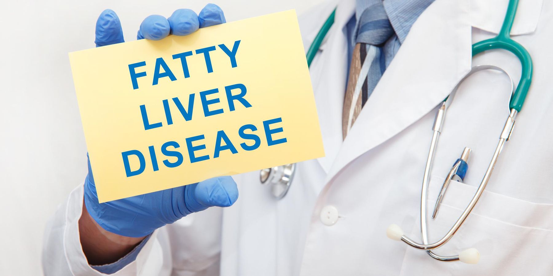 Doctor holding sign with text FATTY LIVER DISEASE