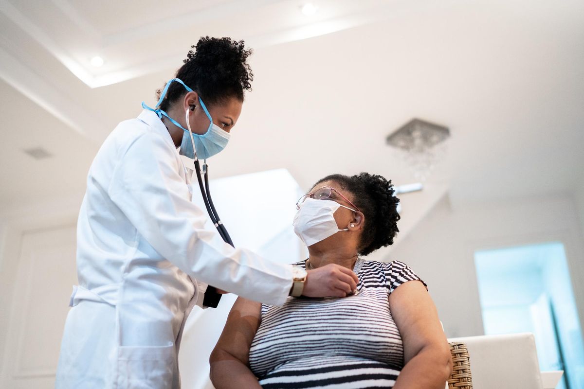 Doctor listening to patient's heartbeat