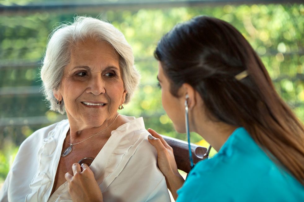 doctor listening to the heart of an older patient