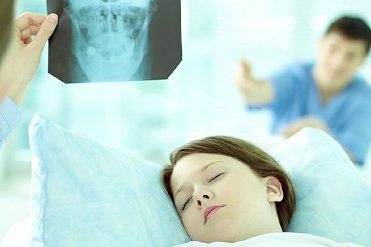 Doctor looking at skull x-ray of little girl