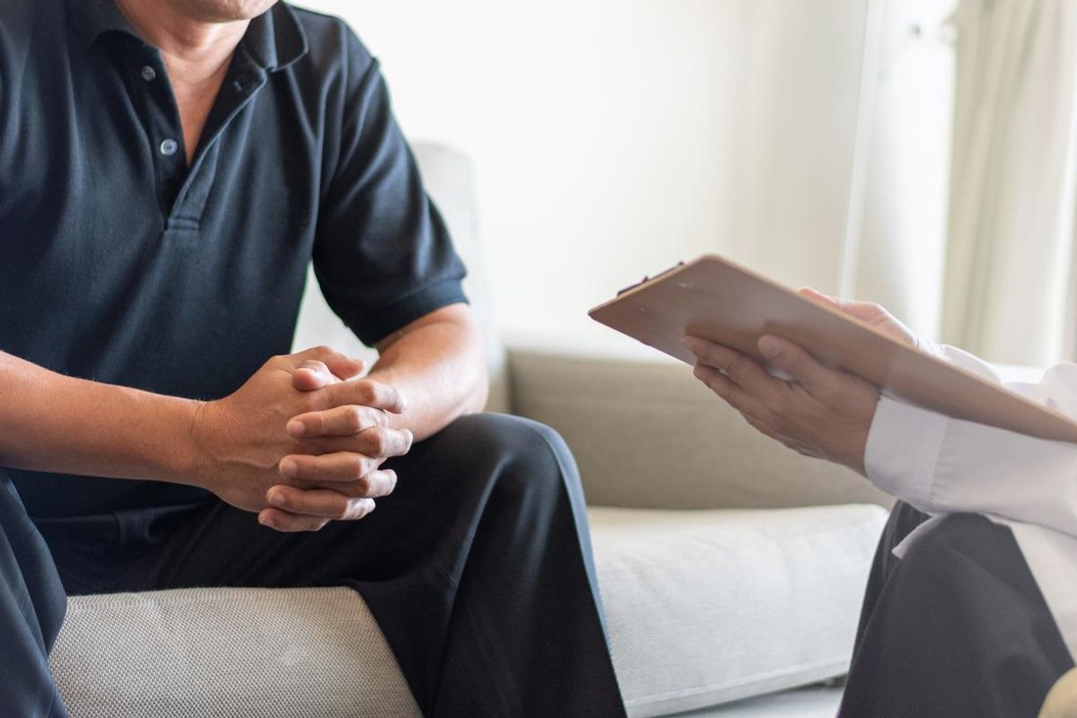 Doctor physician consulting with male patients in hospital exam room
