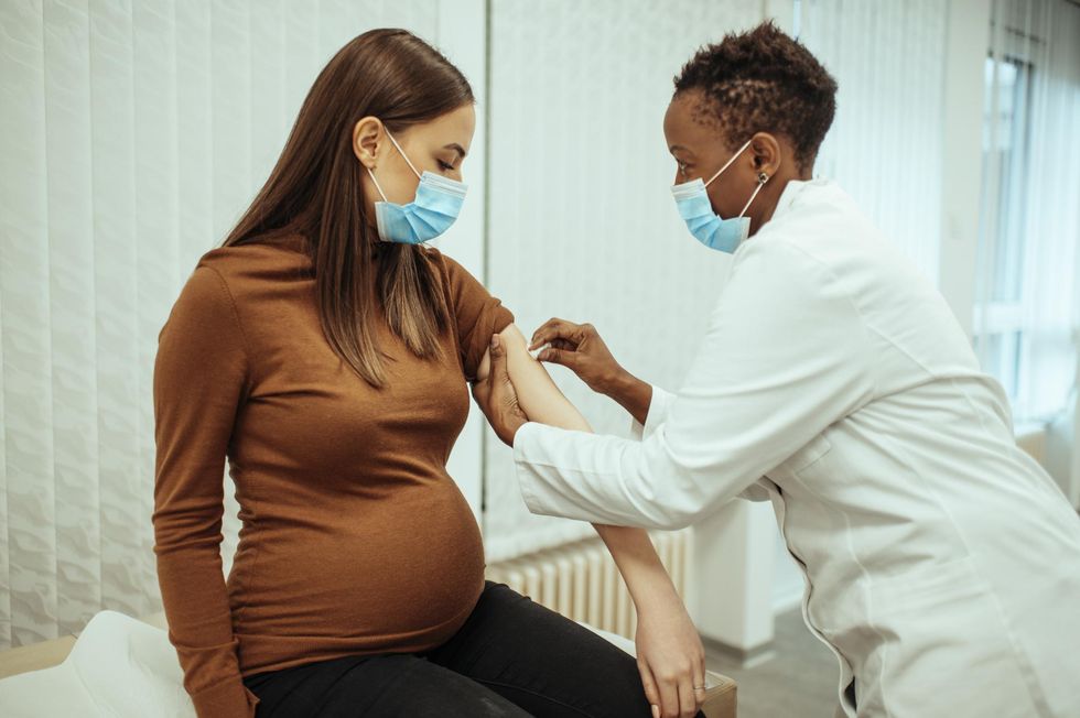 doctor preparing a pregnant woman for vaccination