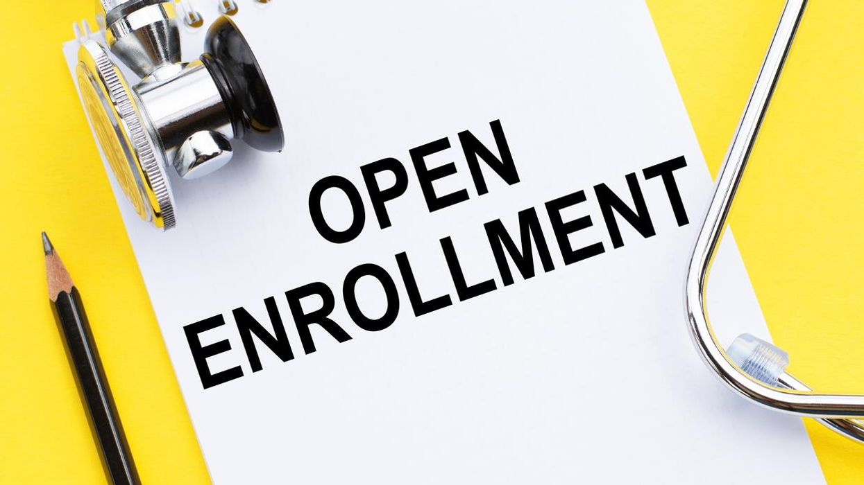 Doctor's yellow desk with notebook and text - Open Enrollment