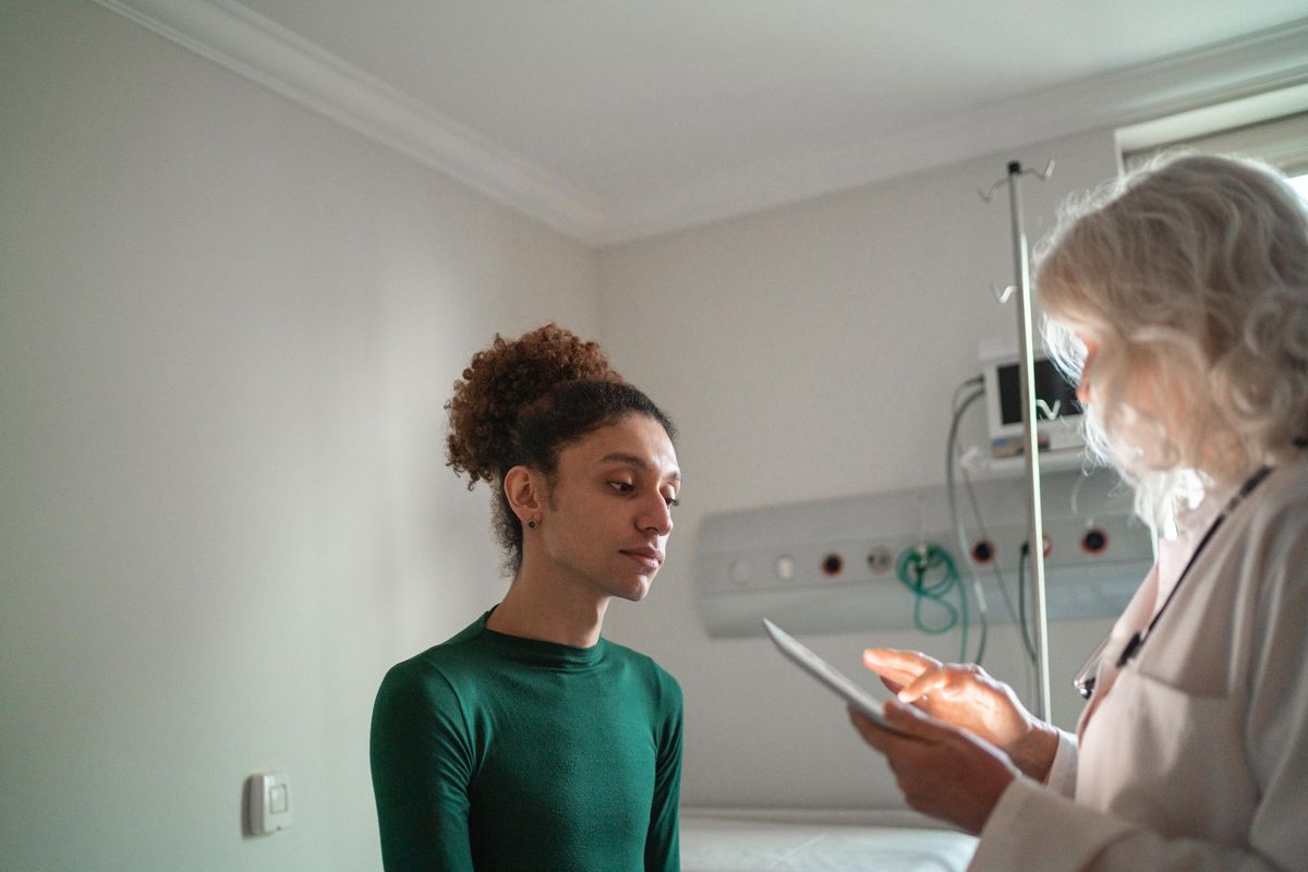 Doctor talking to transgender patient at hospital room