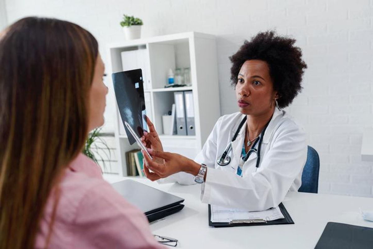 Doctor talking with patient at desk in medical office