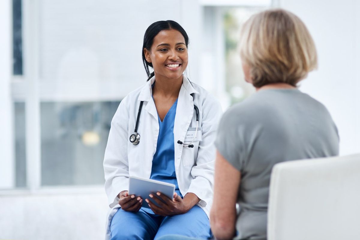 doctor using a digital tablet during a consultation with a senior woman