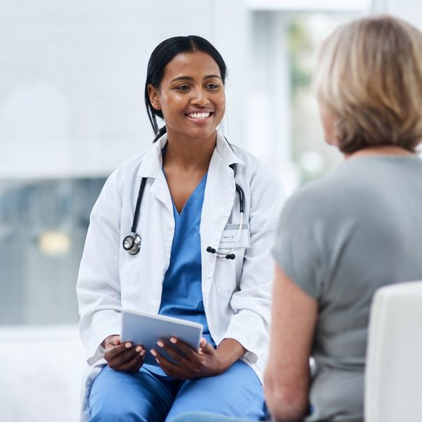 doctor using a digital tablet during a consultation with a senior woman