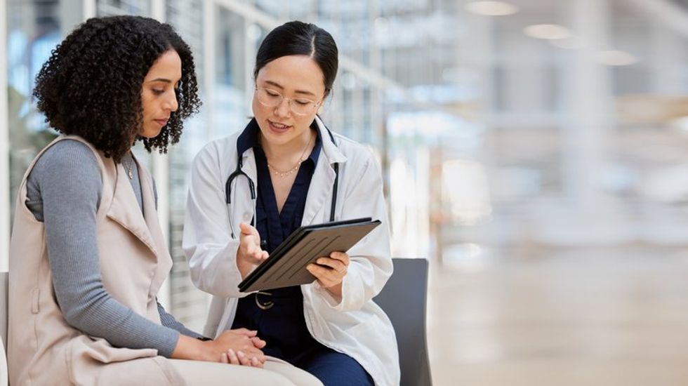 Doctor, woman patient and tablet for consulting with results