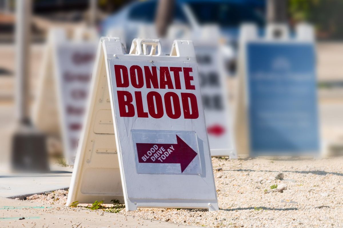 Donate Blood written on a sandwich board sign