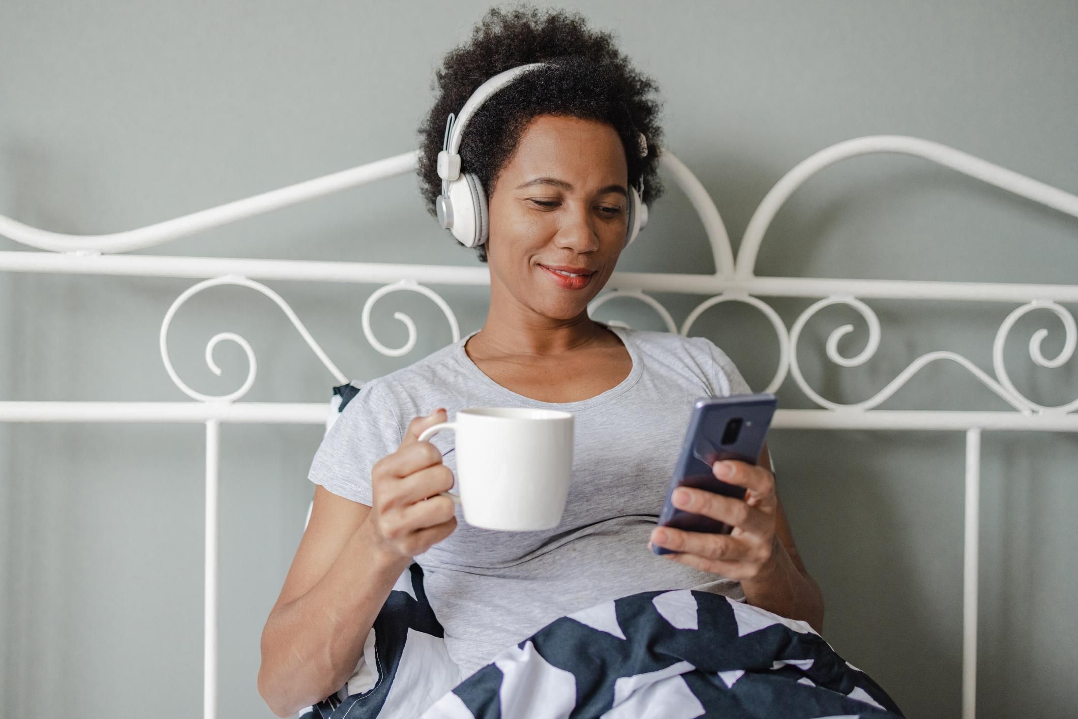 drinking morning coffee in bed while listening to a podcast