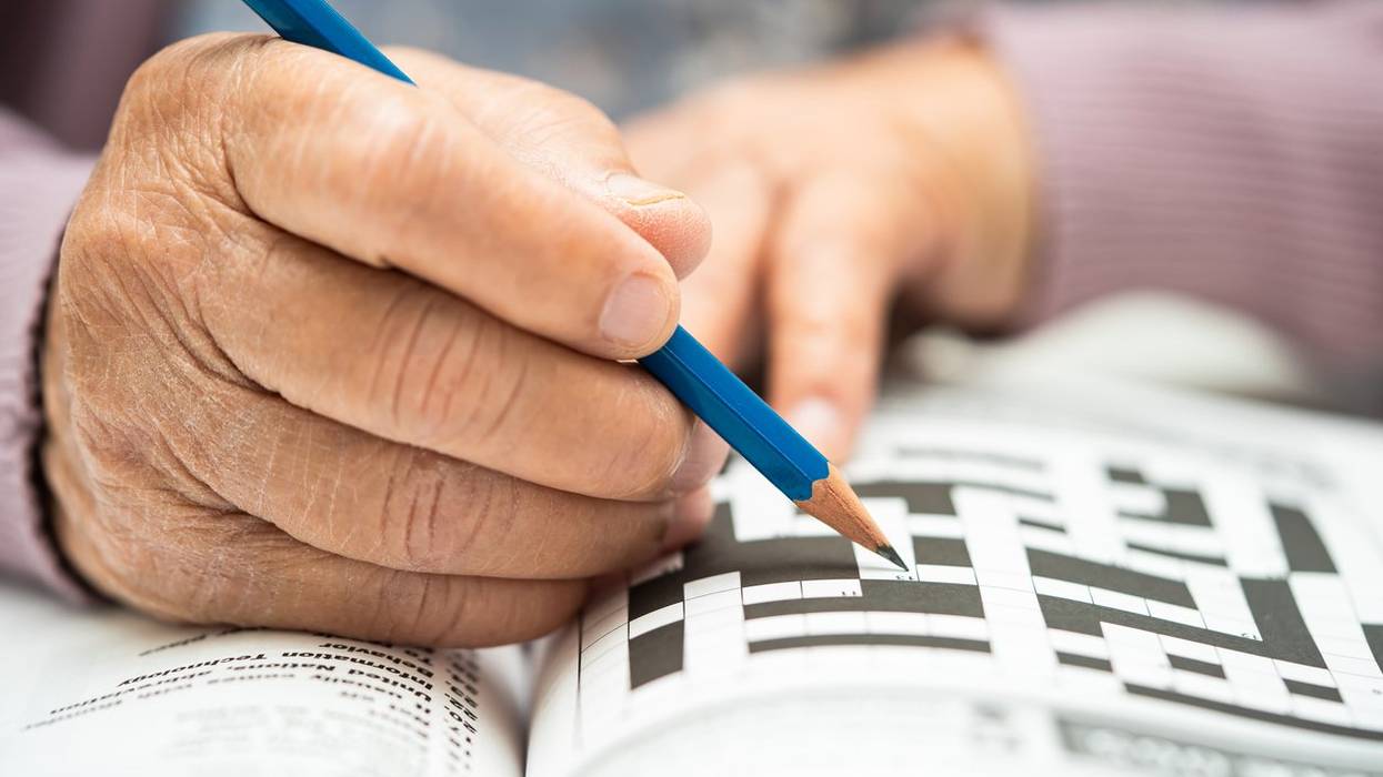 elderly woman playing sudoku puzzle game to practice brain training for dementia prevention